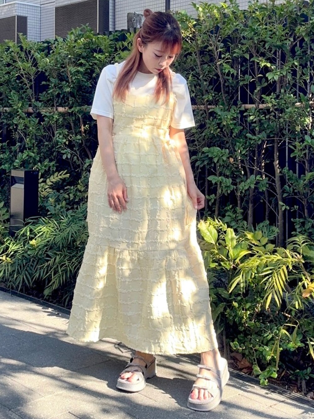 イエロー系のワンピース、ホワイト系のTシャツ/カットソーを着用したレディースの夏コーディネートの2枚目の写真