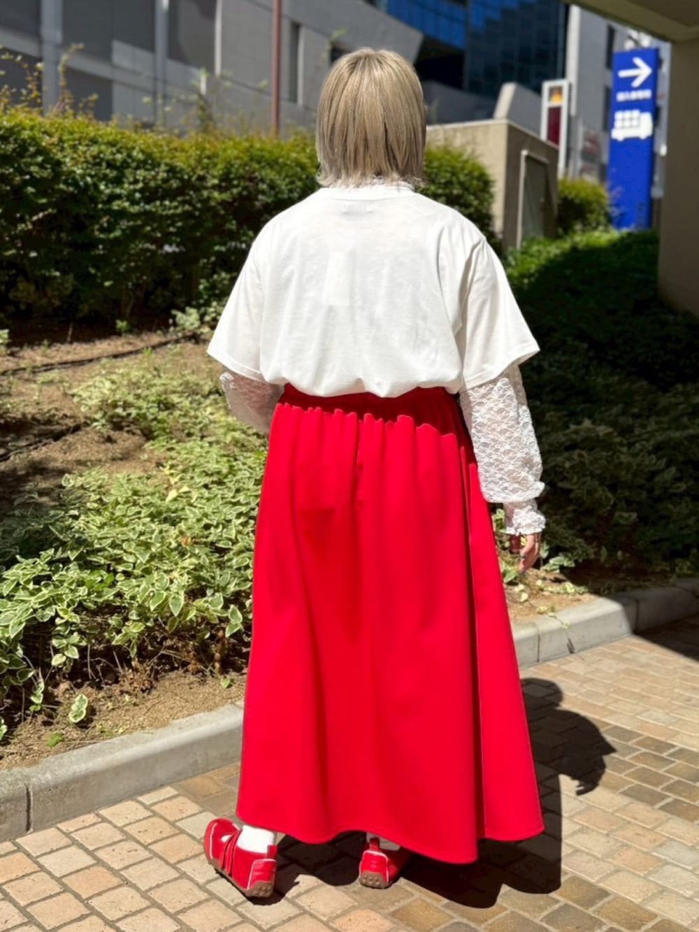 レッド系のスカート、ホワイト系のTシャツ/カットソー、ホワイト系のTシャツ/カットソーを着用したレディースの夏コーディネートの3枚目の写真