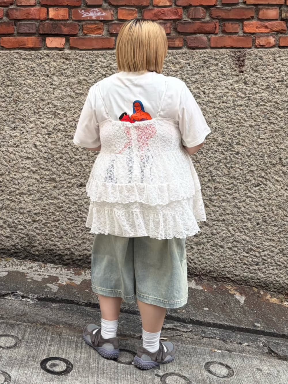 ブルー系のデニムパンツ、ホワイト系のTシャツ/カットソー、ホワイト系のワンピースを着用したレディースの春コーディネートの4枚目の写真