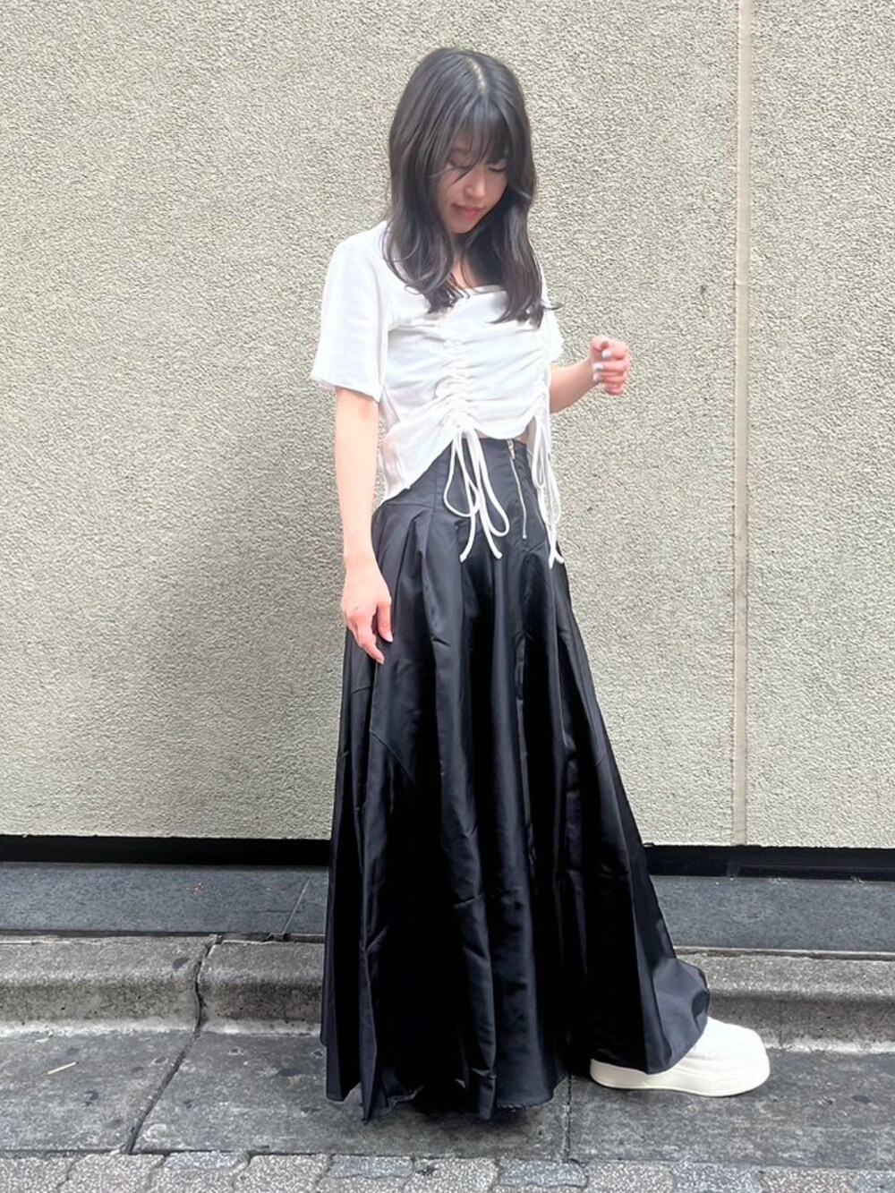 ブラック系のスカート、ホワイト系のTシャツ/カットソーを着用したレディースの夏コーディネートの3枚目の写真