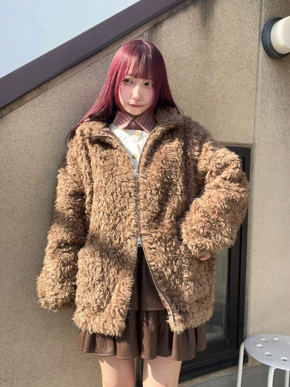 ブラウン系のブルゾン、ブラウン系のスカートを着用したレディースの冬コーディネートの2枚目の写真