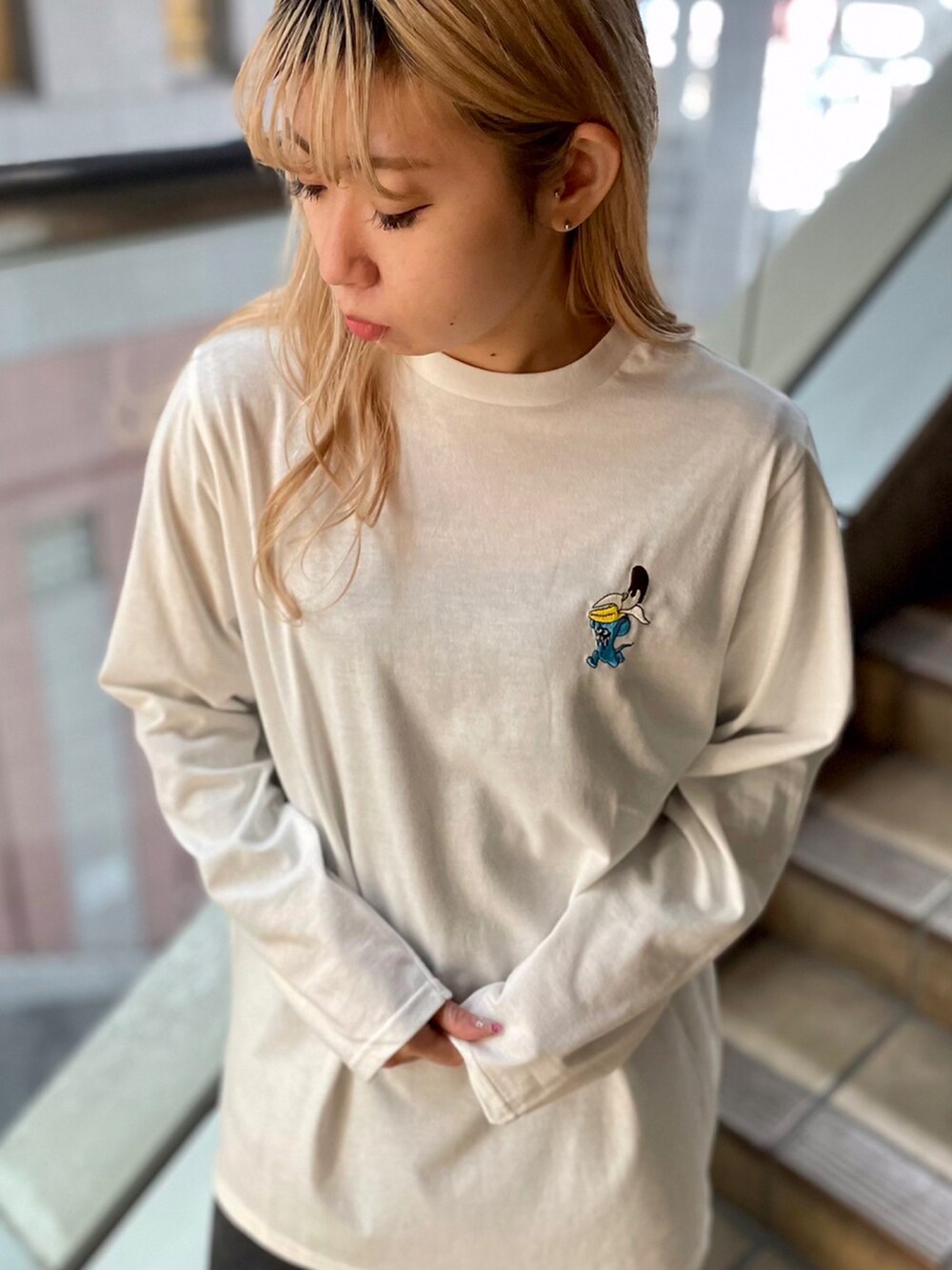 ブラック系のデニムパンツ、ホワイト系のTシャツ/カットソー、ブラック系のナイロンジャケットを着用したレディースの冬コーディネートの2枚目の写真