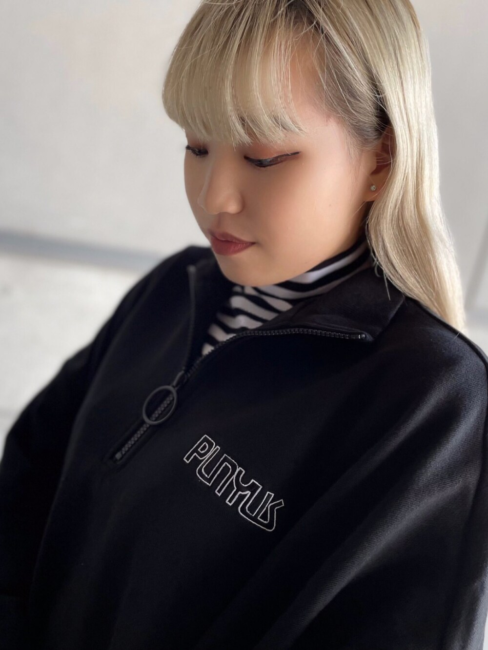 ブラック系のスウェット、ホワイト系のTシャツ/カットソー、ブラック系のブーツを着用したレディースの秋コーディネートの2枚目の写真