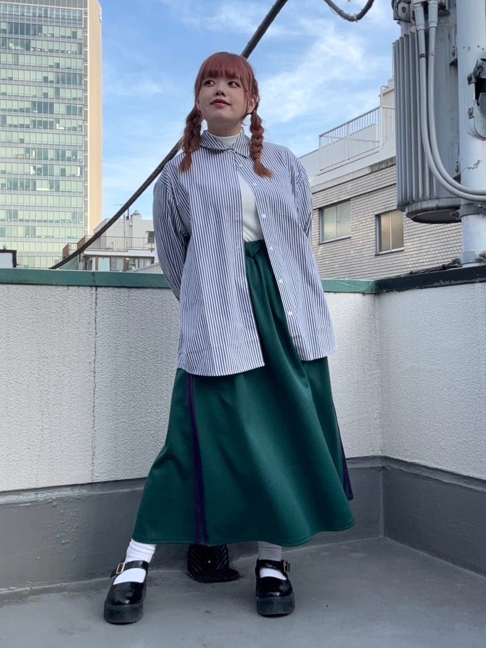 ブルー系のシャツ/ブラウス、グリーン系のスカート、ホワイト系のTシャツ/カットソーを着用したレディースの春コーディネートの3枚目の写真