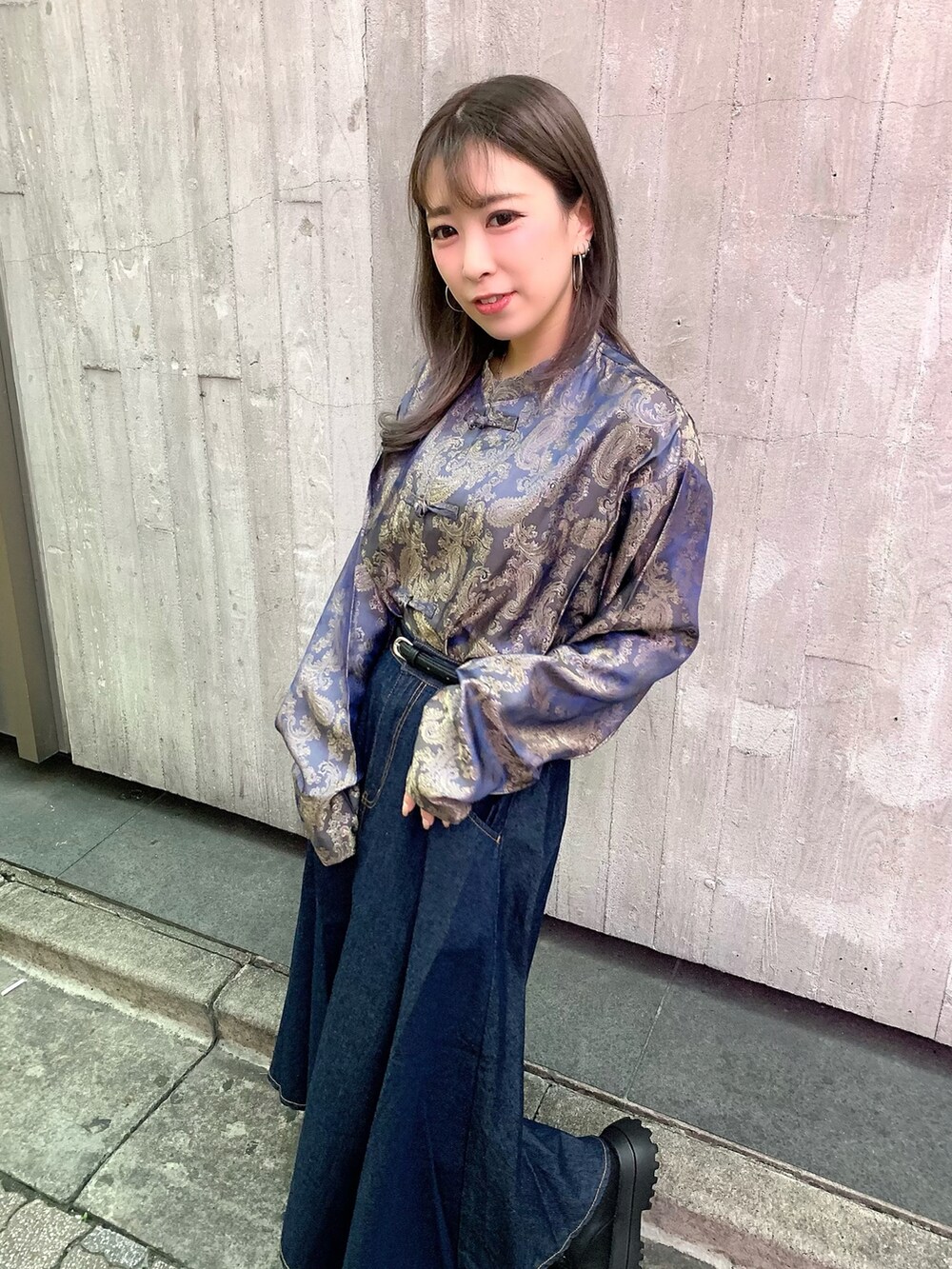 ブルー系のデニムスカート、ブラック系のブーツ、パープル系のシャツ/ブラウスを着用したレディースの秋コーディネートの2枚目の写真