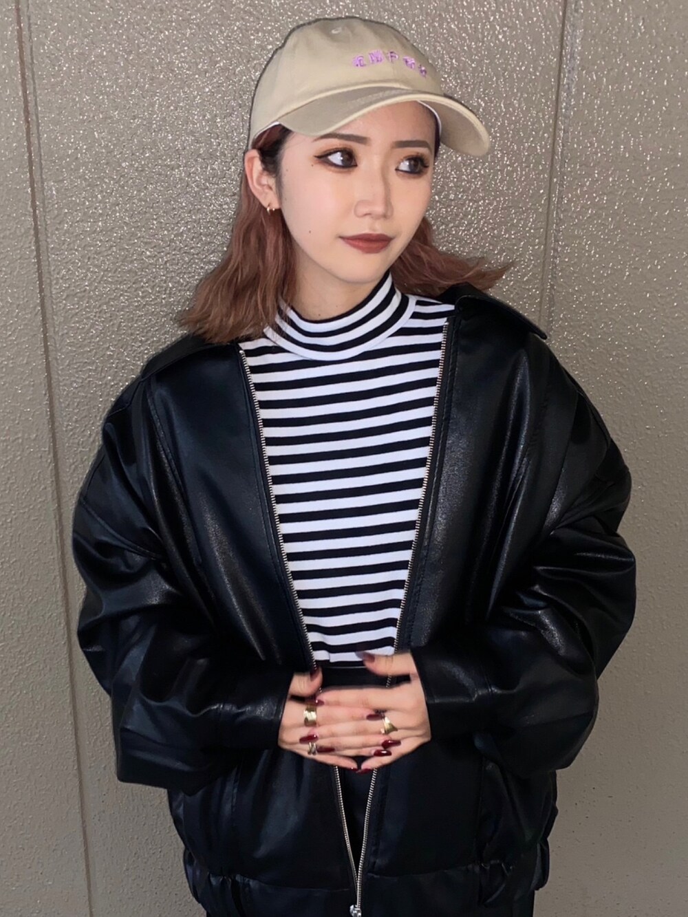 ホワイト系のTシャツ/カットソー、ブラック系のブルゾン、ブラック系のスカートを着用したレディースの秋コーディネートの2枚目の写真