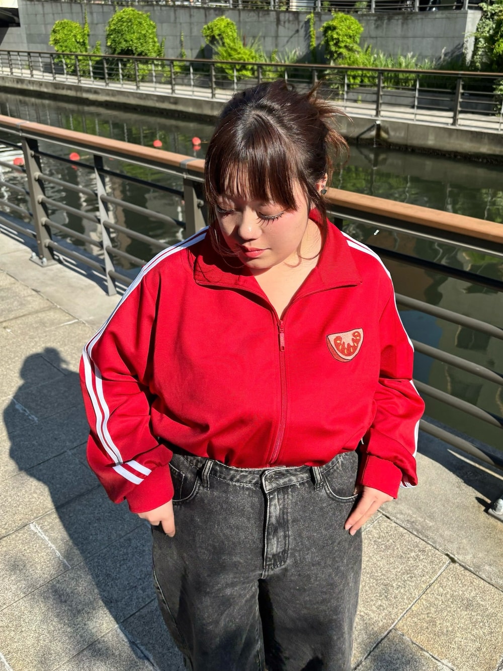 ブラック系のデニムパンツ、レッド系のジャージを着用したレディースの夏コーディネートの2枚目の写真