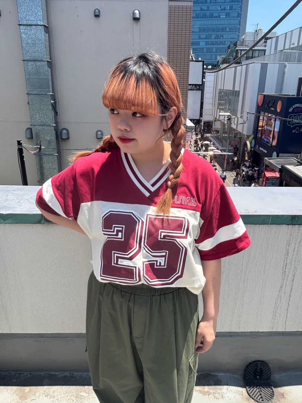グリーン系のカーゴパンツ、レッド系のTシャツ/カットソーを着用したレディースの夏コーディネートの2枚目の写真