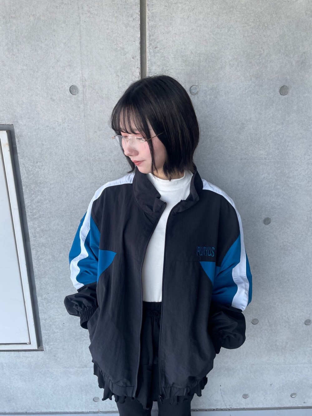 ブラック系のその他パンツ、ブラック系のナイロンジャケット、ホワイト系のTシャツ/カットソーを着用したレディースの春コーディネートの5枚目の写真