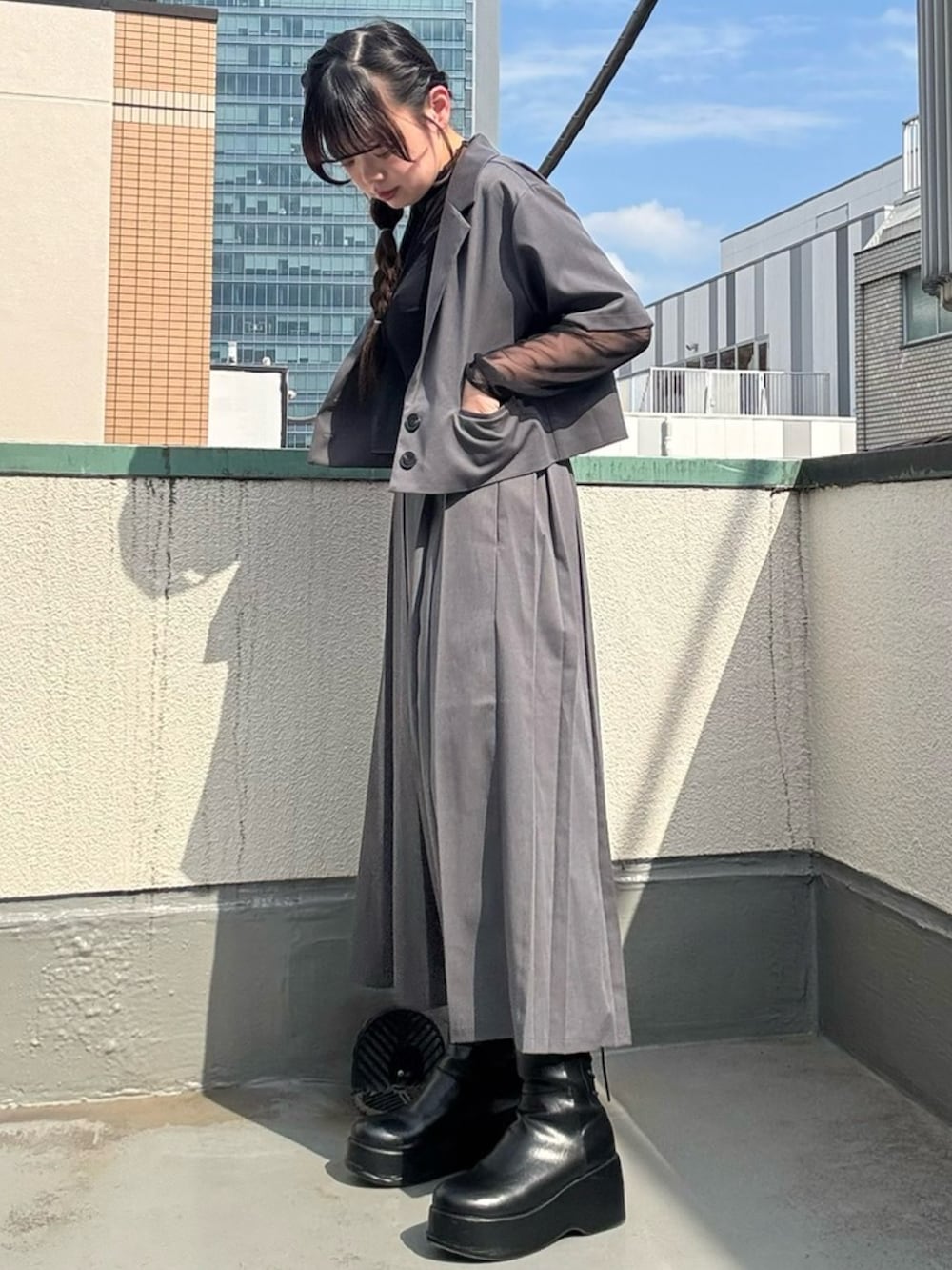 グレー系のスカート、グレー系のテーラードジャケット、ブラック系のTシャツ/カットソーを着用したレディースの春コーディネートの2枚目の写真