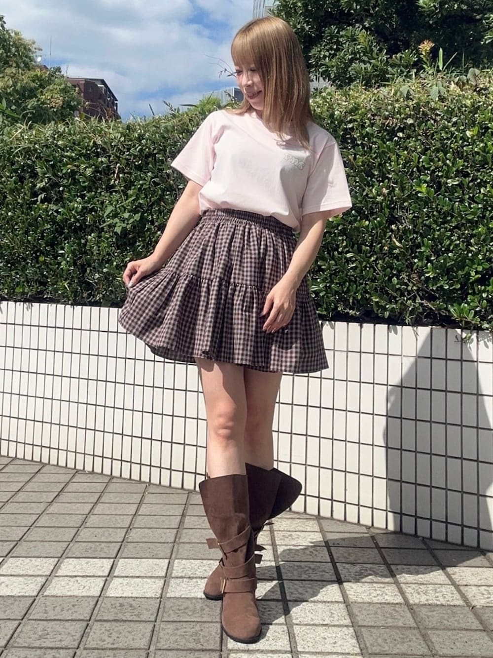 ブラウン系のスカート、ピンク系のTシャツ/カットソーを着用したレディースの夏コーディネートの2枚目の写真