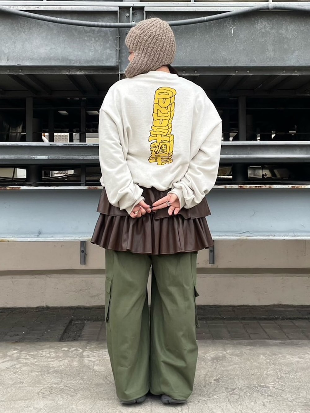 ベージュ系のスウェット、ブラウン系のスカート、グリーン系のカーゴパンツを着用したレディースの冬コーディネートの3枚目の写真