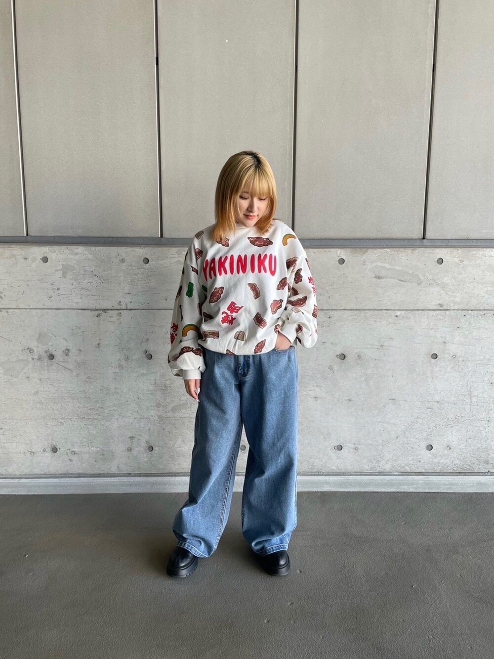 レッド系のスウェット、ブルー系のデニムパンツを着用したレディースの冬コーディネートの4枚目の写真