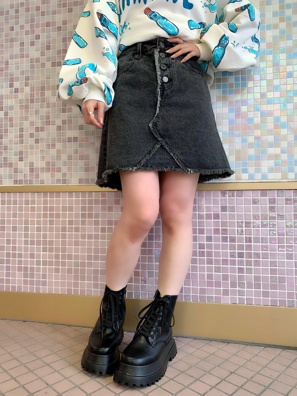 ブルー系のスウェット、ブラック系のデニムスカート、ブラック系のブーツを着用したレディースの冬コーディネートの3枚目の写真