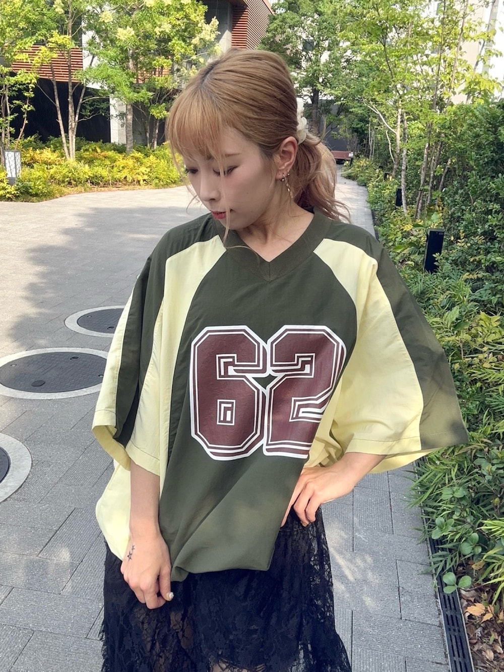 グリーン系のTシャツ/カットソー、ブラック系のスカートを着用したレディースの秋コーディネートの5枚目の写真