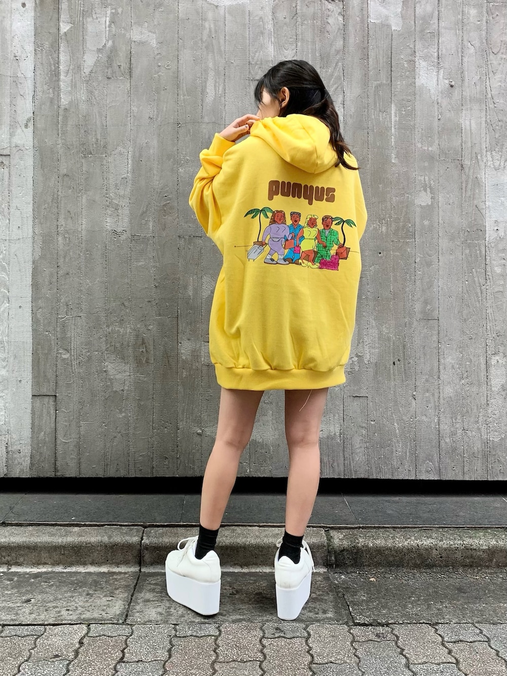 イエロー系のパーカー、ホワイト系のスニーカーを着用したレディースの秋コーディネートの2枚目の写真