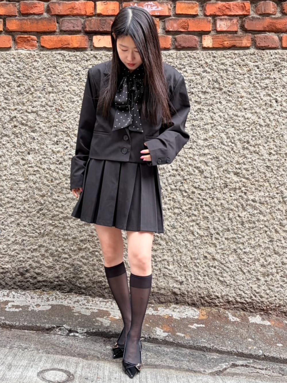 ブラック系のスカート、ブラック系のテーラードジャケット、ブラック系のシャツ/ブラウスを着用したレディースの冬コーディネートの2枚目の写真