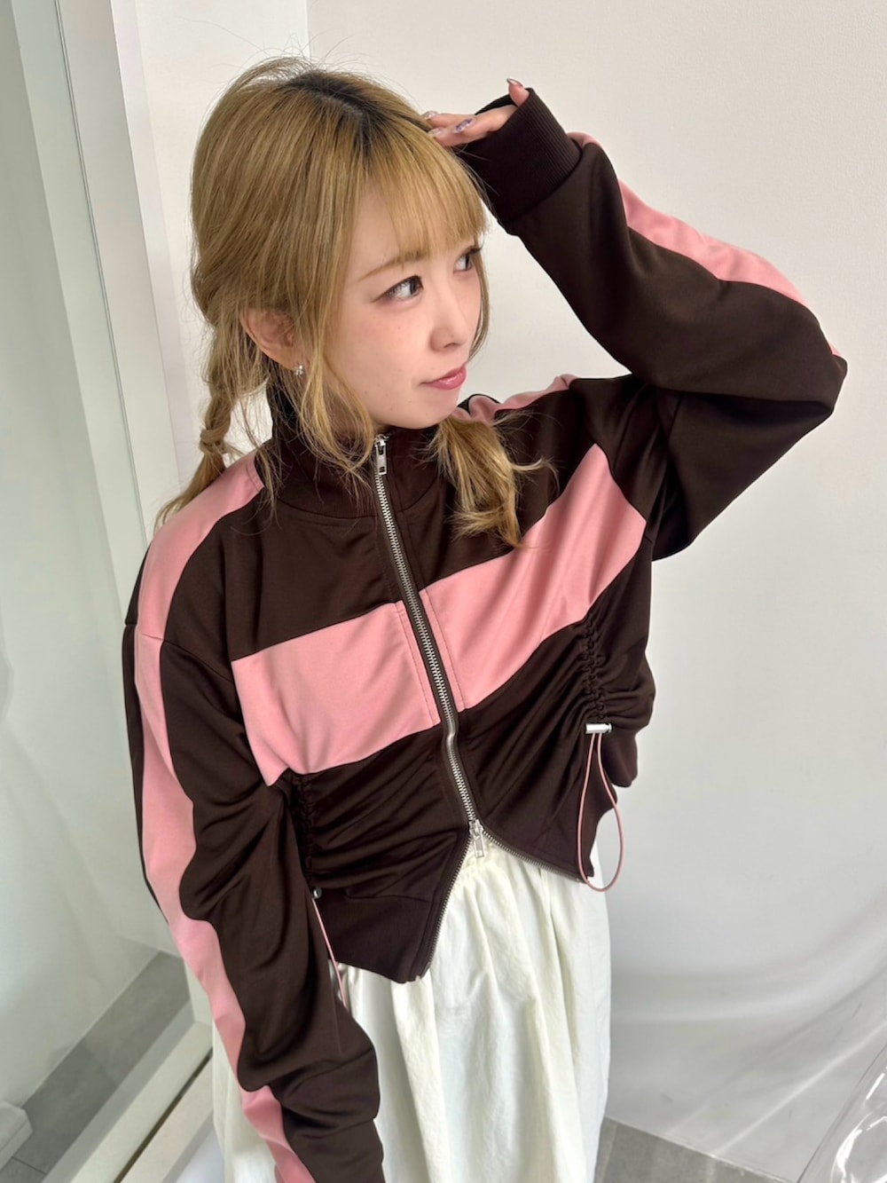 ホワイト系のワンピース、ブラウン系のジャージ、ブルー系のデニムパンツを着用したレディースの秋コーディネートの5枚目の写真