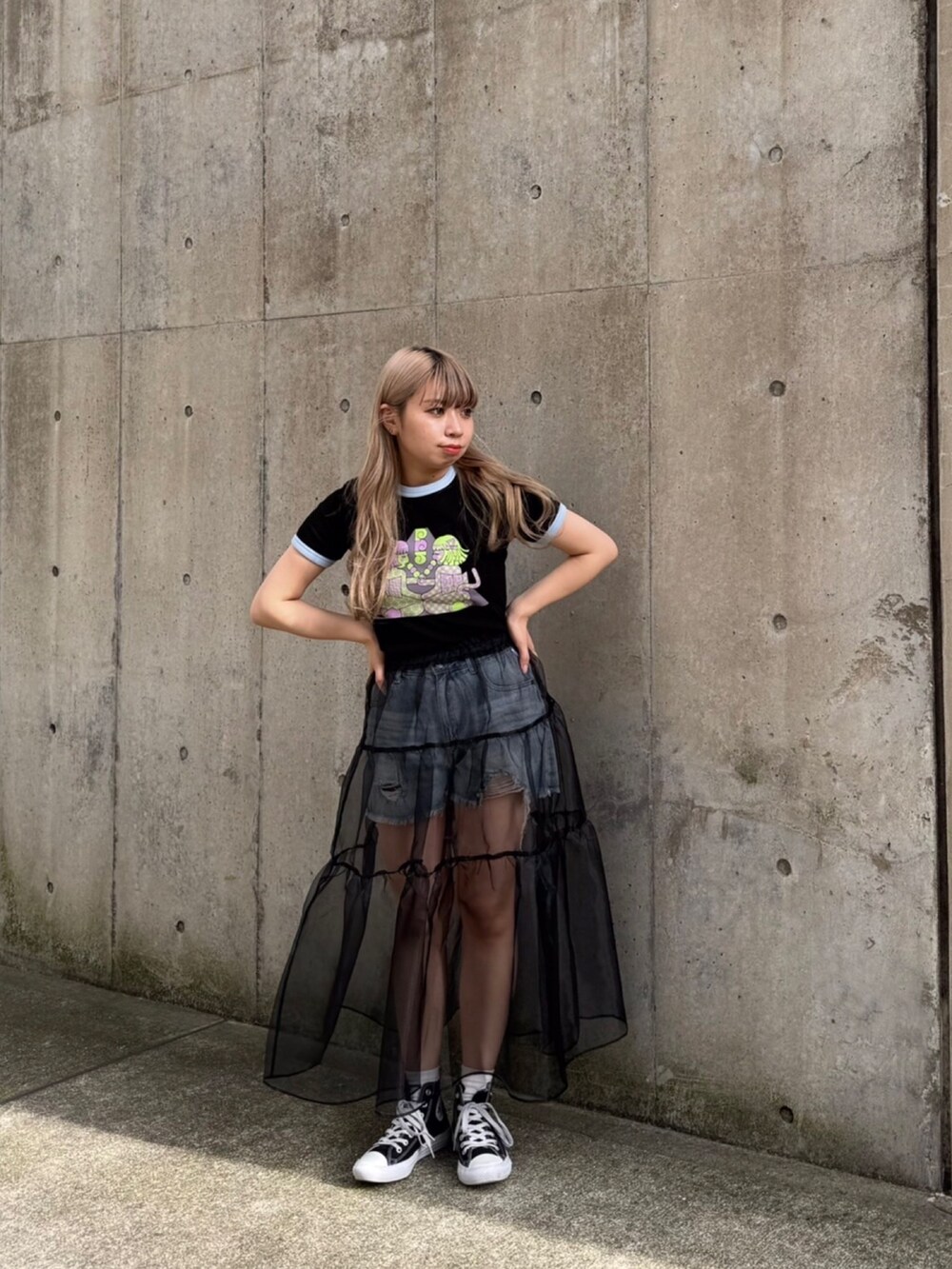 ブラック系のTシャツ/カットソー、ブルー系のデニムパンツ、ブラック系のスカートを着用したレディースの春コーディネートの2枚目の写真