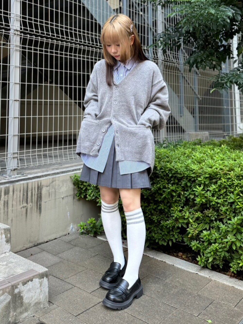 ブルー系のシャツ/ブラウス、グレー系のカーディガン/ボレロ、グレー系のスカートを着用したレディースの秋コーディネートの2枚目の写真