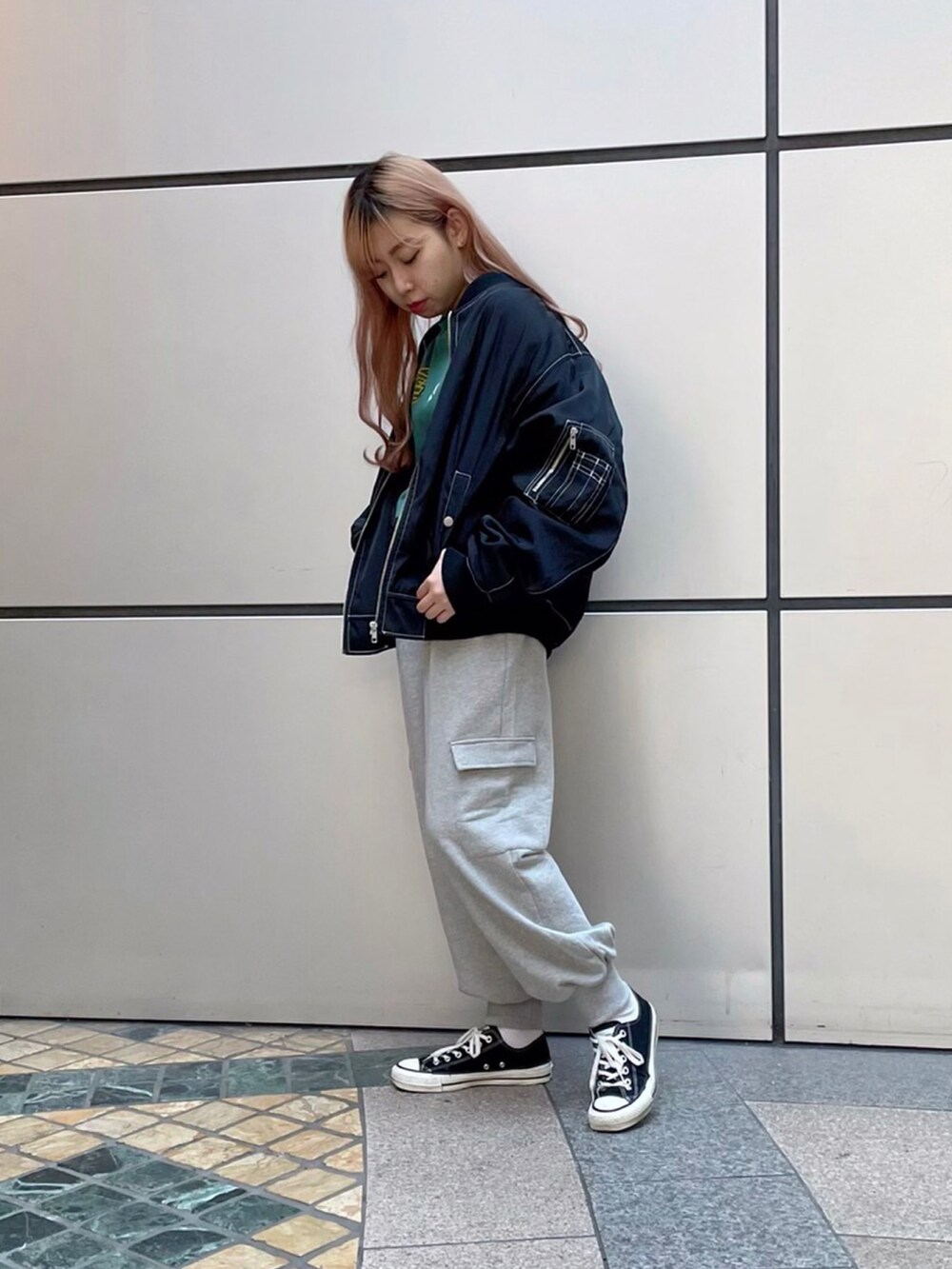 グリーン系のTシャツ/カットソー、グレー系のスウェットパンツ、ブラック系のMA-1を着用したレディースの秋コーディネートの2枚目の写真