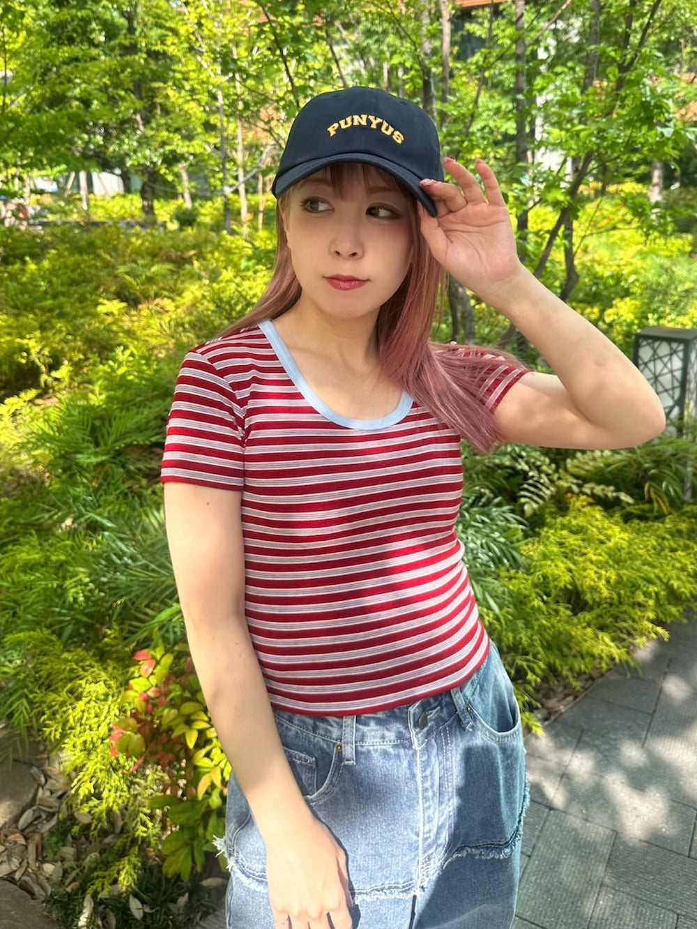 レッド系のTシャツ/カットソー、ブルー系のキャップを着用したレディースの春コーディネートの2枚目の写真