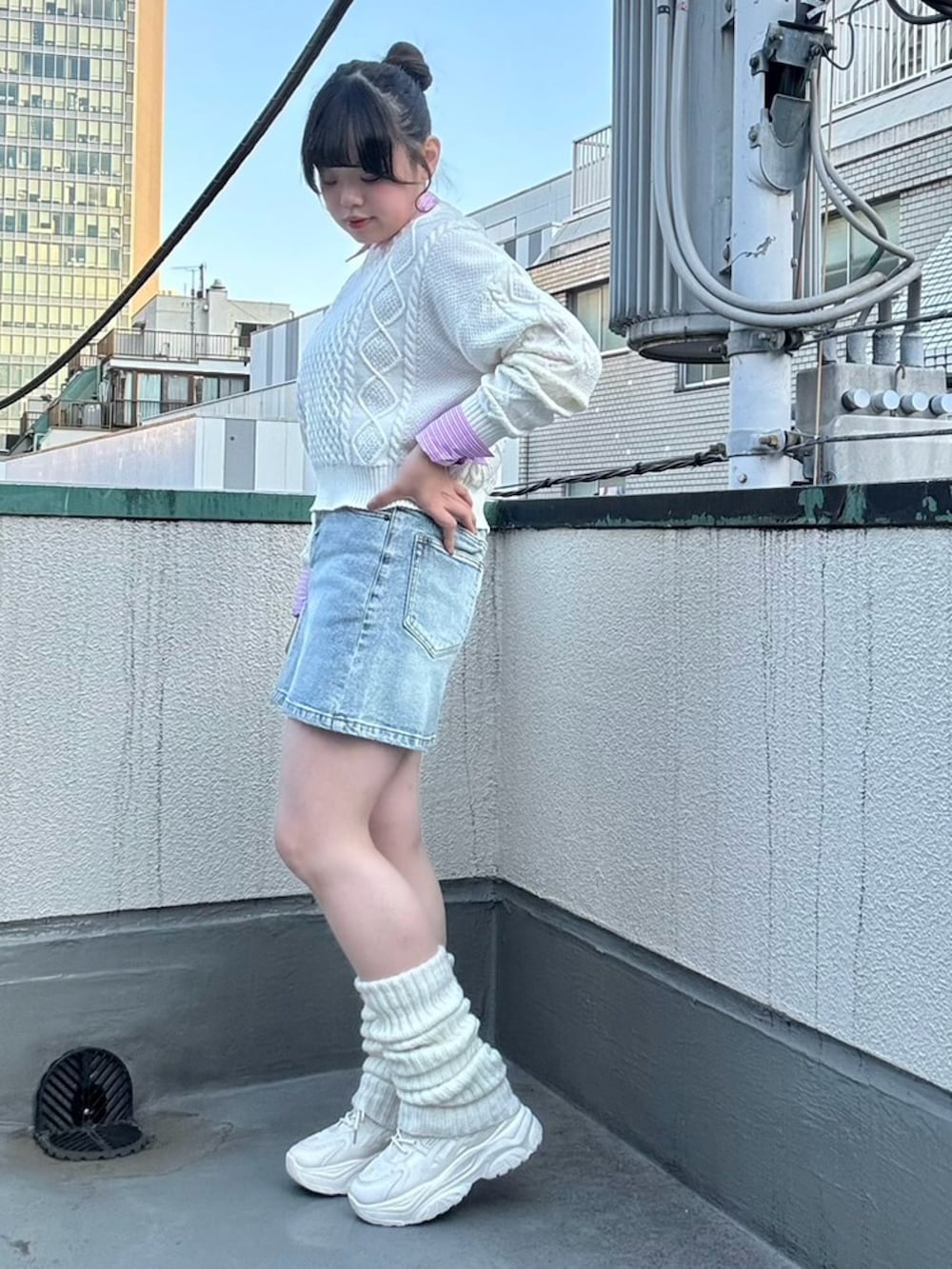 ブルー系のデニムスカート、ホワイト系のニット/セーター、ピンク系のシャツ/ブラウスを着用したレディースの冬コーディネートの3枚目の写真