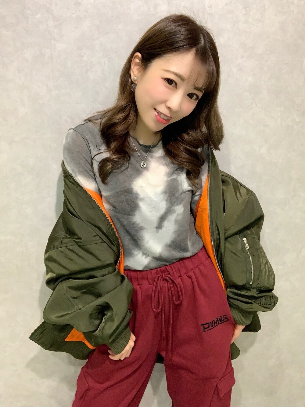 ブラック系のTシャツ/カットソー、グリーン系のMA-1、レッド系のスウェットパンツを着用したレディースの秋コーディネートの2枚目の写真
