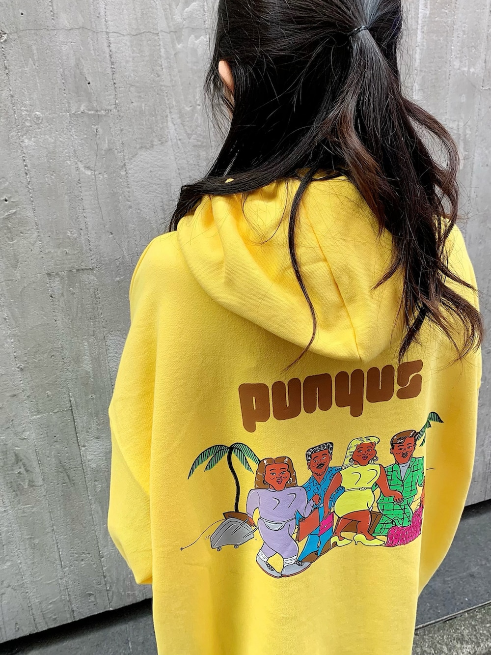 イエロー系のパーカー、ホワイト系のスニーカーを着用したレディースの秋コーディネートの3枚目の写真