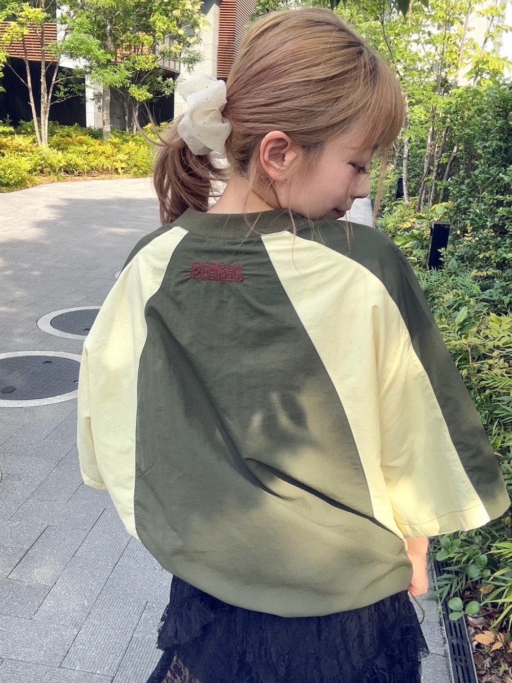 グリーン系のTシャツ/カットソー、ブラック系のスカートを着用したレディースの秋コーディネートの6枚目の写真