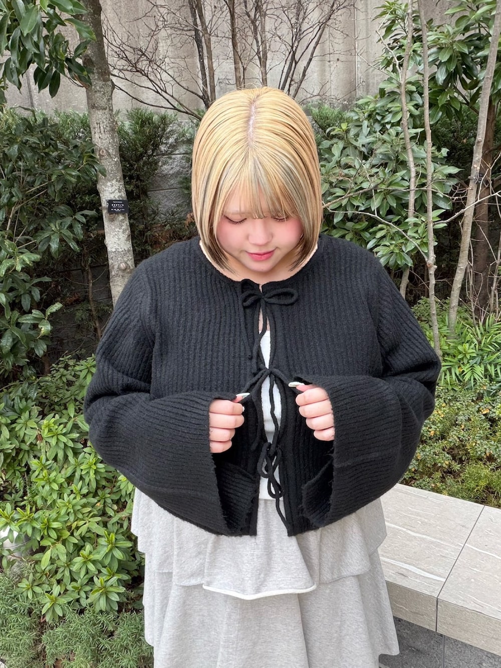 グレー系のスカート、ブラック系のカーディガン/ボレロを着用したレディースの冬コーディネートの4枚目の写真