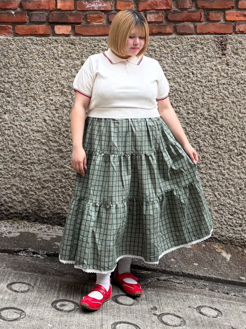 ホワイト系のポロシャツ、グリーン系のワンピースを着用したレディースの夏コーディネートの2枚目の写真