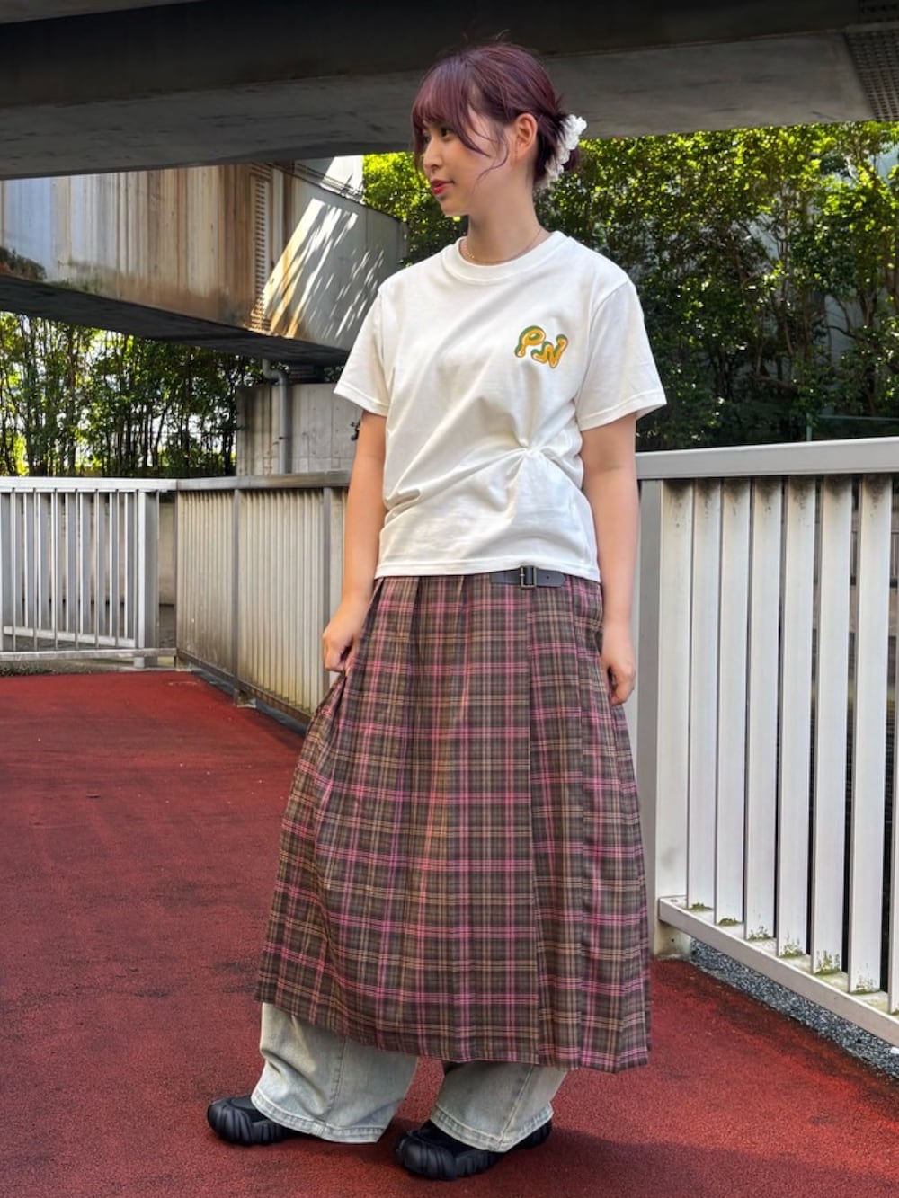 グリーン系のスカート、ホワイト系のTシャツ/カットソー、ブルー系のデニムパンツを着用したレディースの夏コーディネートの2枚目の写真