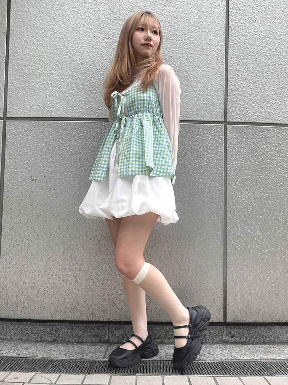 イエロー系のキャミソール、ホワイト系のスカート、ホワイト系のTシャツ/カットソーを着用したレディースの春コーディネートの4枚目の写真