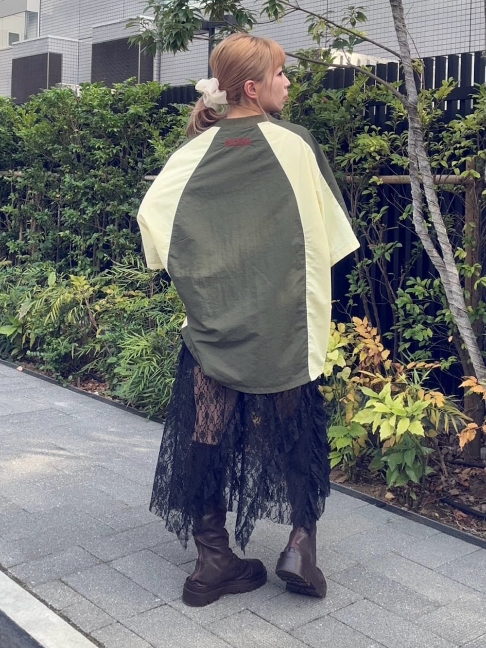 グリーン系のTシャツ/カットソー、ブラック系のスカートを着用したレディースの秋コーディネートの4枚目の写真