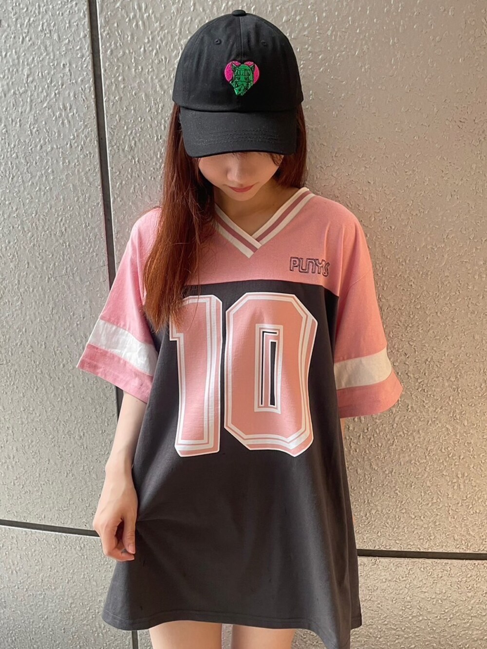 ピンク系のTシャツ/カットソー、ブラック系のキャップを着用したレディースの夏コーディネートの2枚目の写真