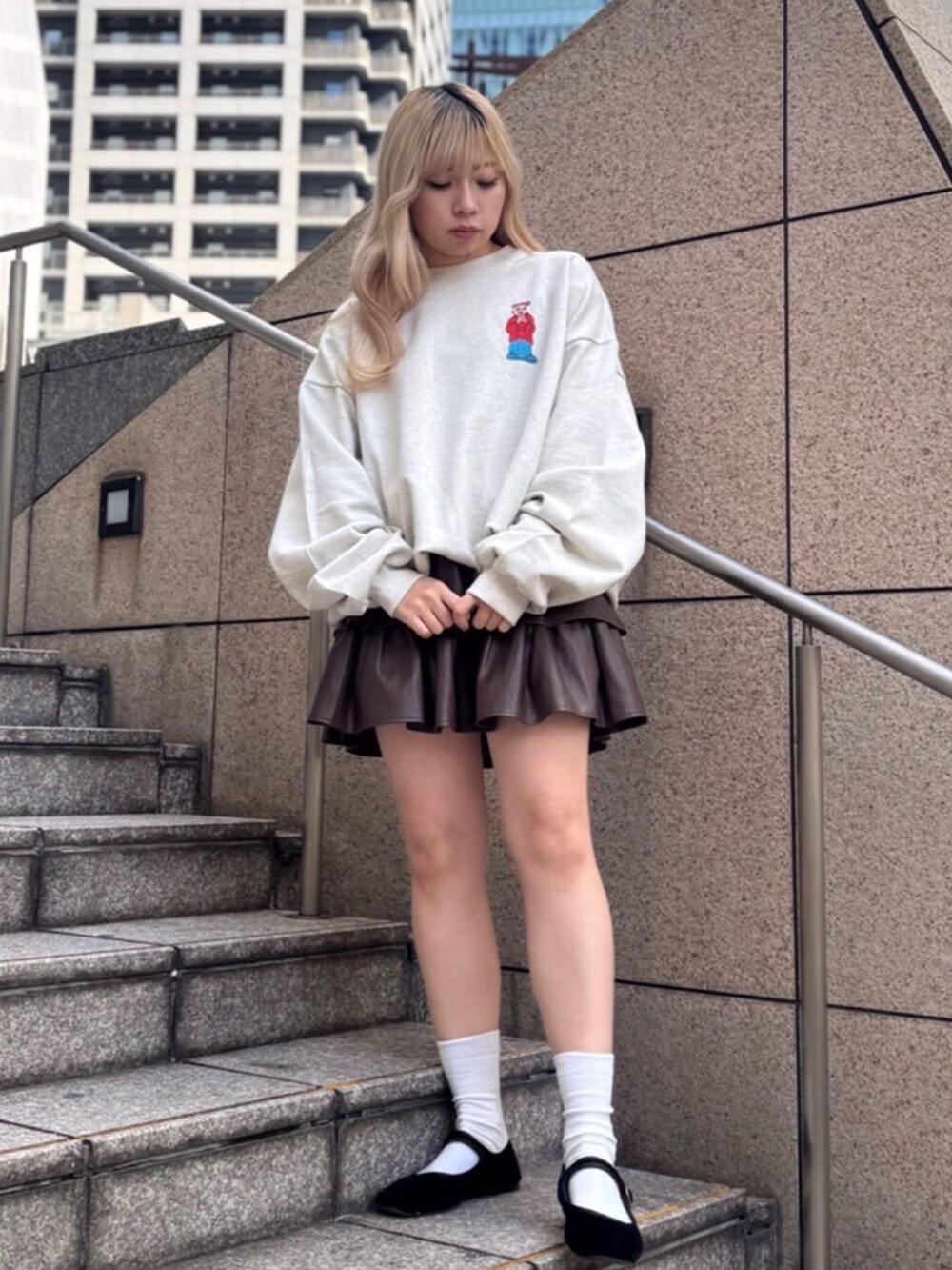 ベージュ系のスウェット、ブラウン系のスカートを着用したレディースの冬コーディネートの3枚目の写真