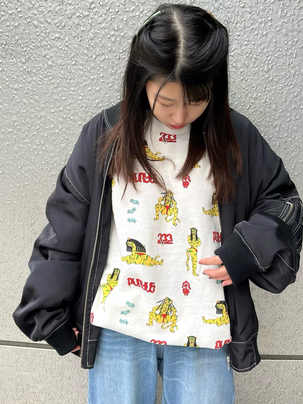 ブルー系のデニムパンツ、ブラック系のMA-1、ホワイト系のスウェットを着用したレディースの冬コーディネートの3枚目の写真