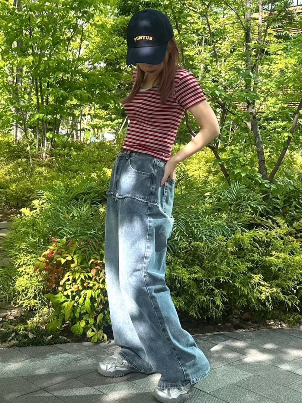 ブルー系のデニムパンツ、レッド系のTシャツ/カットソー、ブルー系のキャップを着用したレディースの春コーディネートの2枚目の写真
