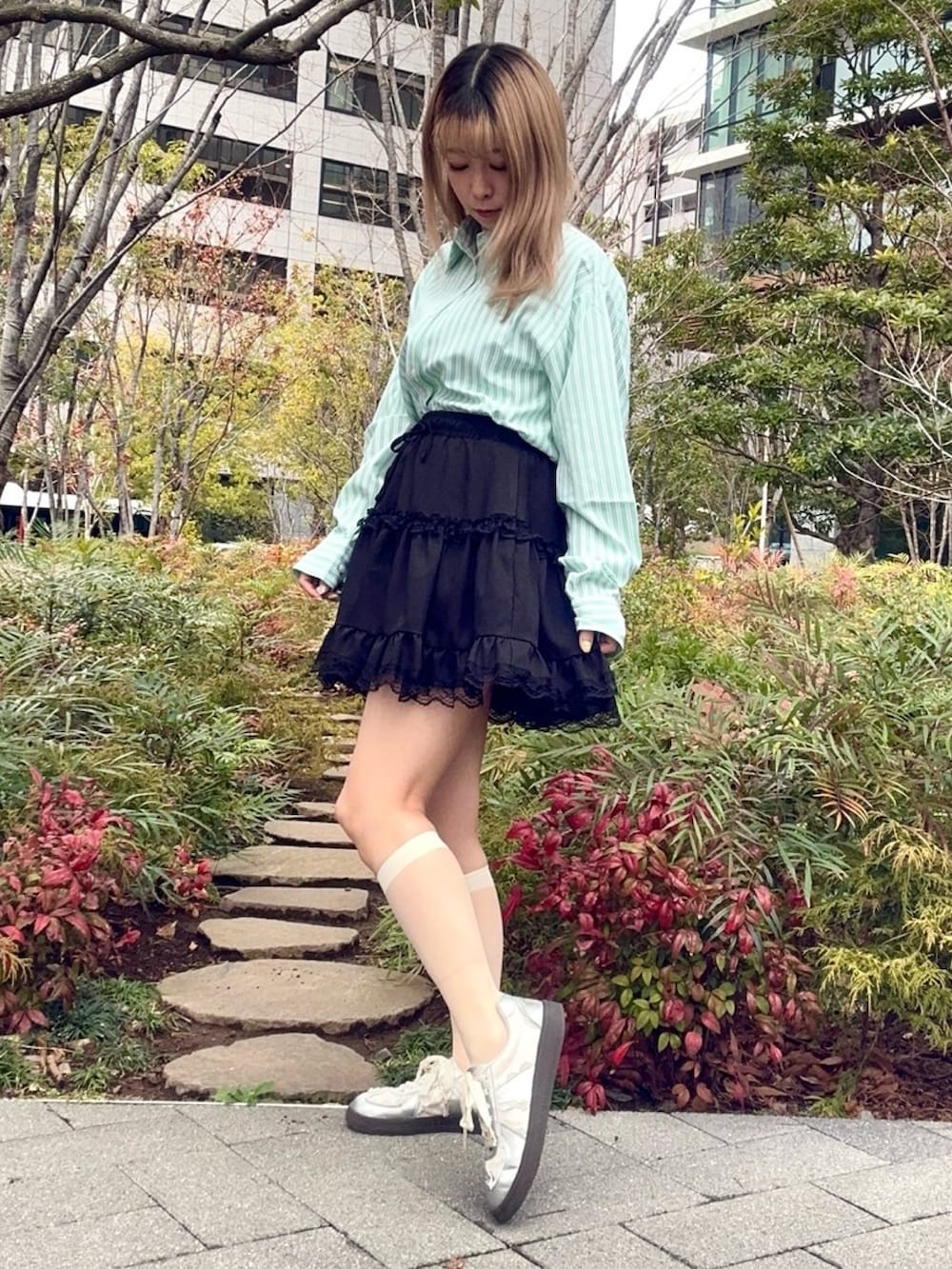 ブラック系のスカート、グリーン系のシャツ/ブラウスを着用したレディースの冬コーディネートの2枚目の写真