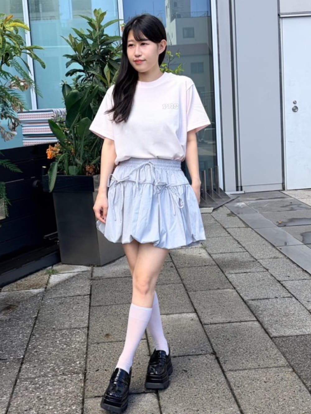 グレー系のスカート、ピンク系のTシャツ/カットソーを着用したレディースの夏コーディネートの2枚目の写真