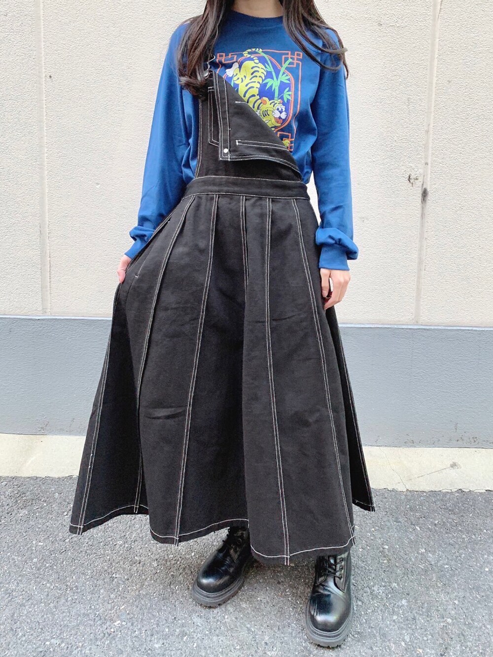 ブラック系のジャンパースカート、ブルー系のTシャツ/カットソーを着用したレディースの秋コーディネートの2枚目の写真