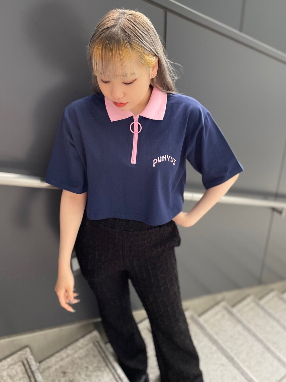 ブルー系のポロシャツ、ブラック系のその他パンツを着用したレディースの春コーディネートの2枚目の写真