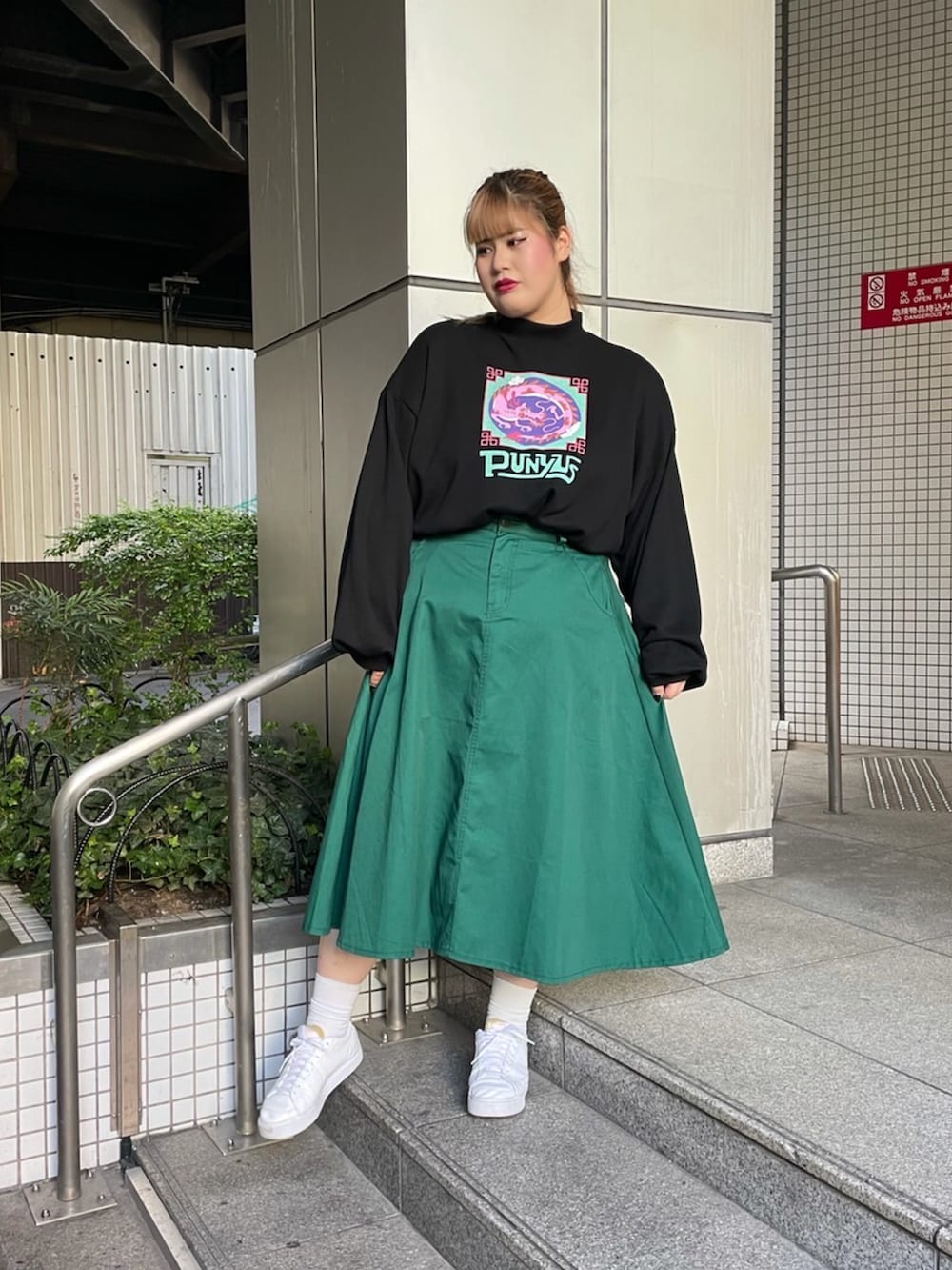 グリーン系のスカート、ブラック系のMA-1、ブラック系のスウェットを着用したレディースの秋コーディネートの2枚目の写真