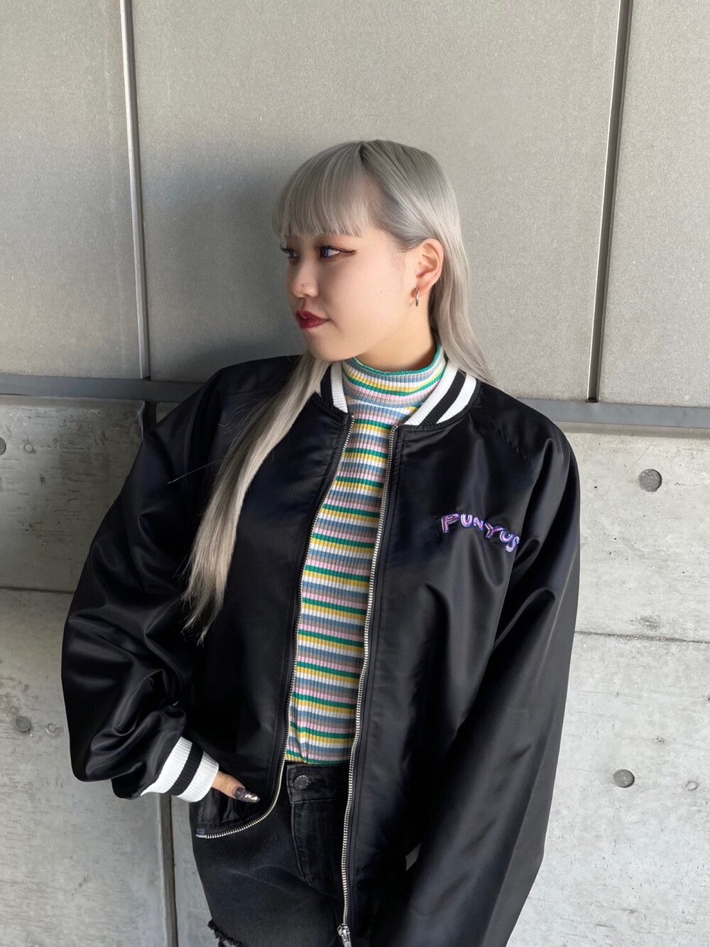 グリーン系のTシャツ/カットソー、ブラック系のブルゾン、ブラック系のデニムパンツを着用したレディースの冬コーディネートの3枚目の写真