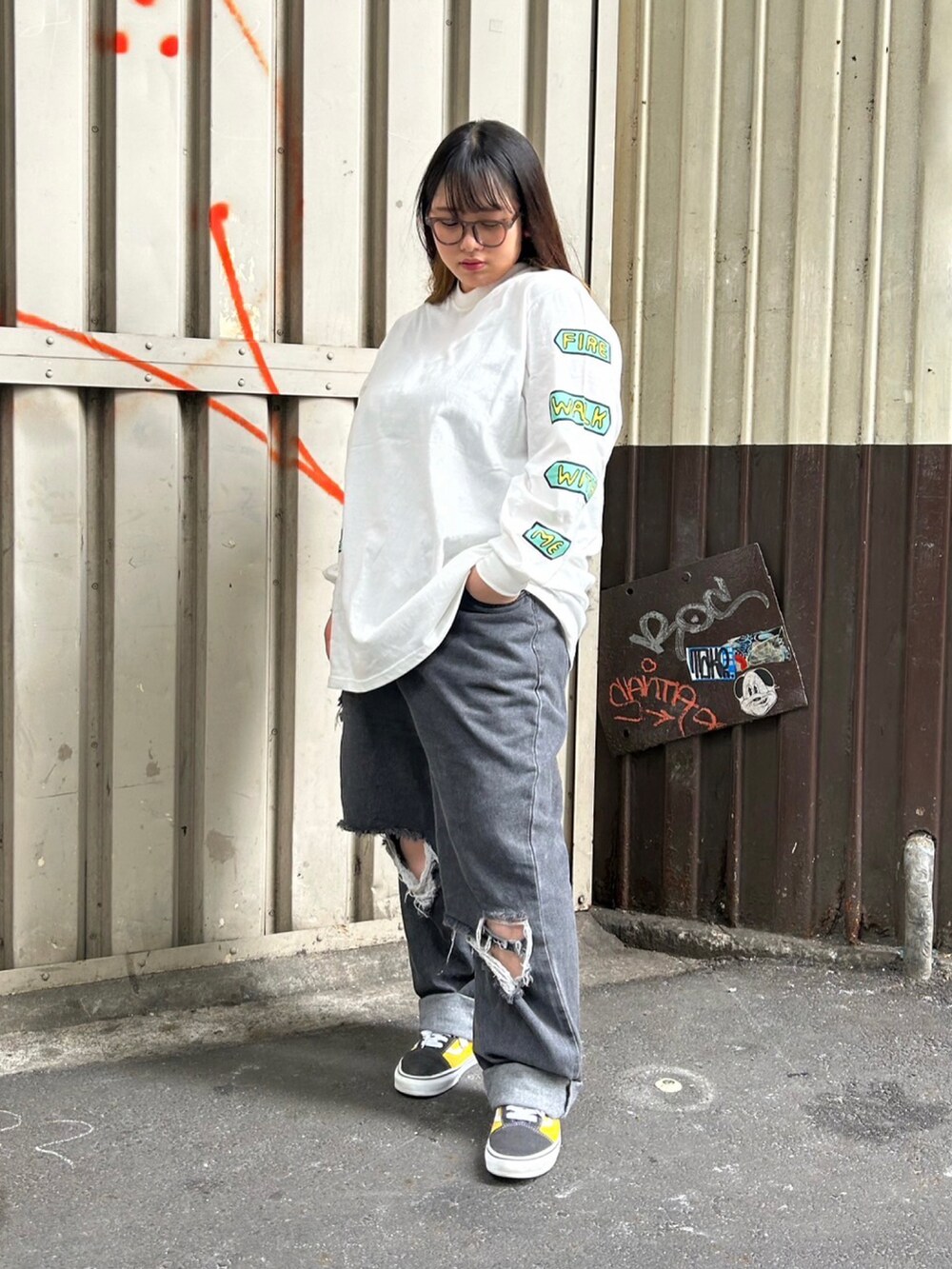 ブラック系のダウンベスト、ブラック系のデニムパンツ、ホワイト系のTシャツ/カットソーを着用したレディースの秋コーディネートの2枚目の写真