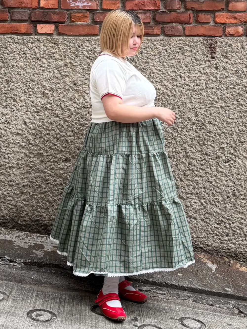 ホワイト系のポロシャツ、グリーン系のワンピースを着用したレディースの夏コーディネートの4枚目の写真