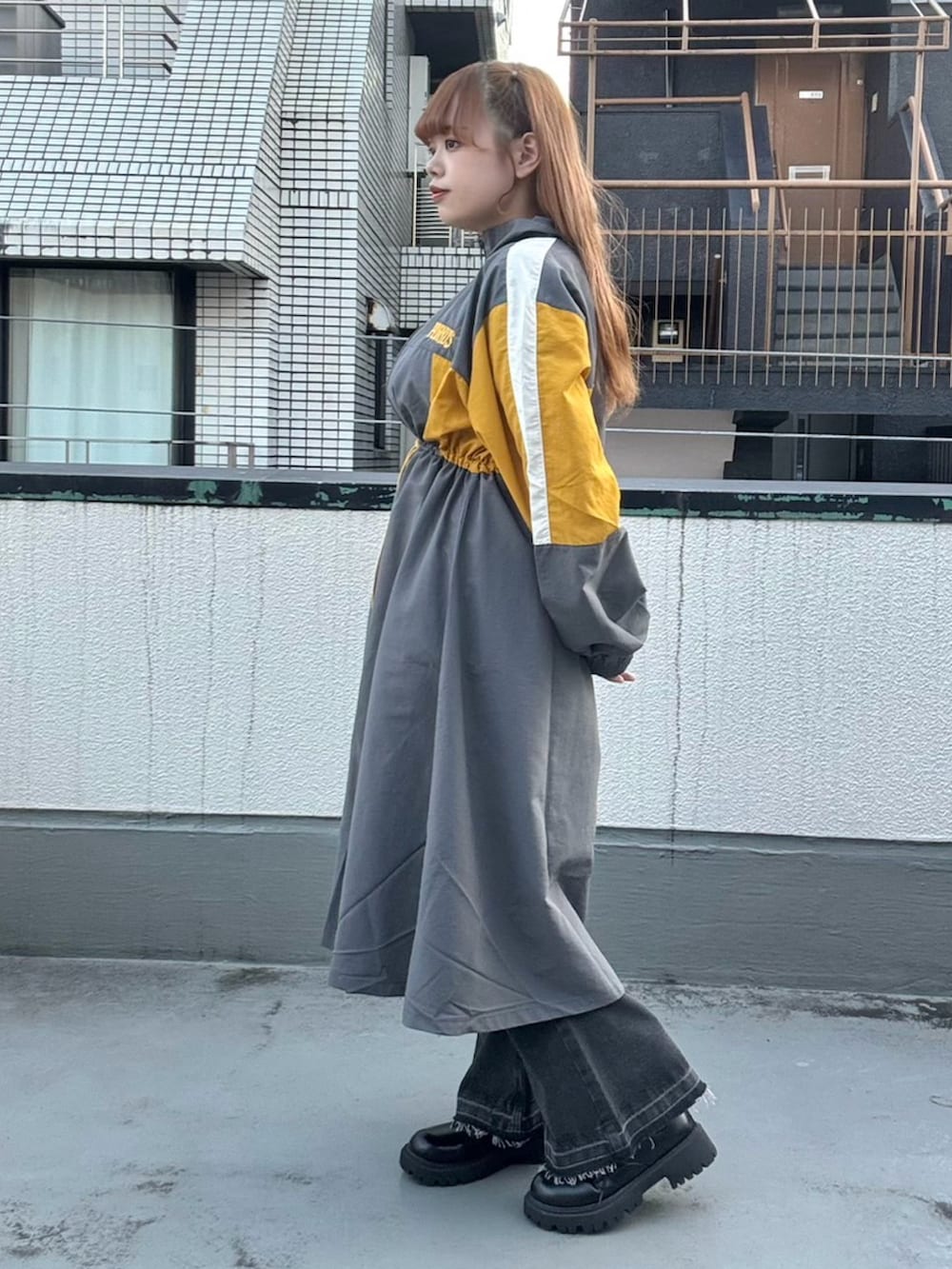 グレー系のワンピース、ブラック系のデニムパンツを着用したレディースの秋コーディネートの3枚目の写真