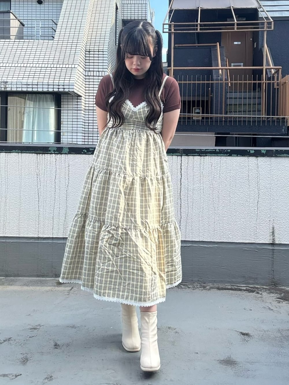 イエロー系のワンピース、ブラウン系のニット/セーターを着用したレディースの夏コーディネートの3枚目の写真