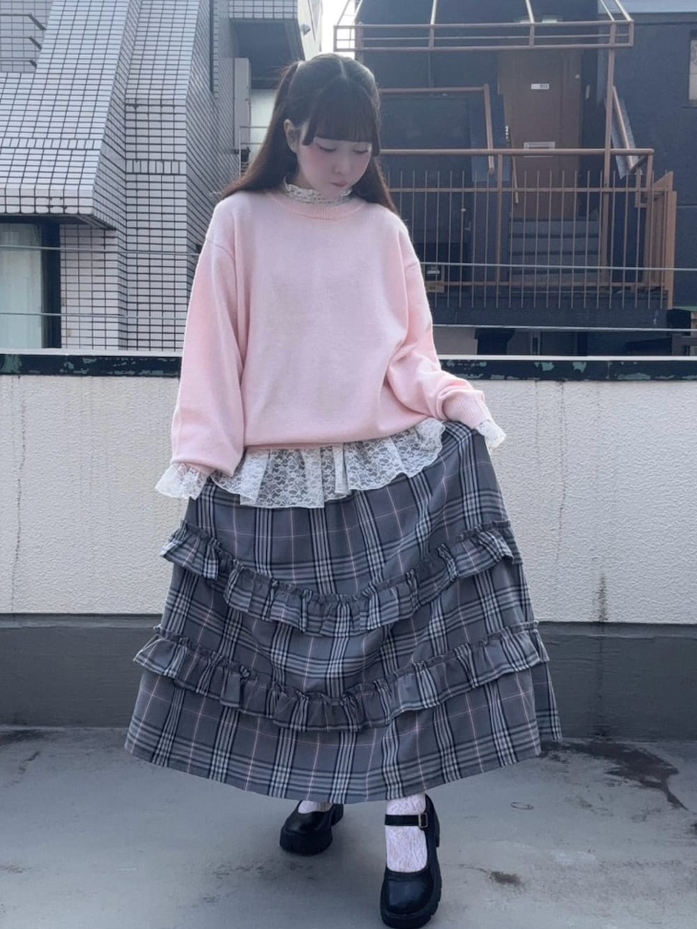 グレー系のスカート、ピンク系のニット/セーター、ホワイト系のTシャツ/カットソーを着用したレディースの冬コーディネートの2枚目の写真